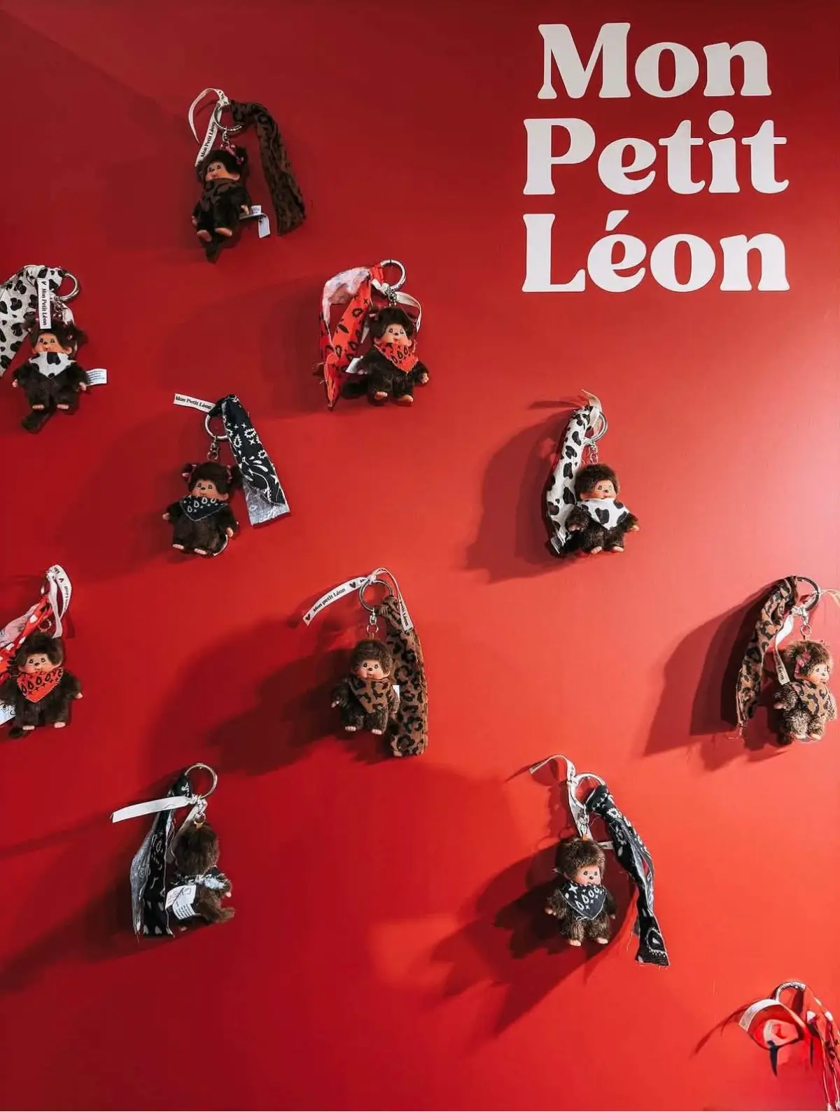 Porte-clés Mon Petit Léon exposés sur un mur rouge